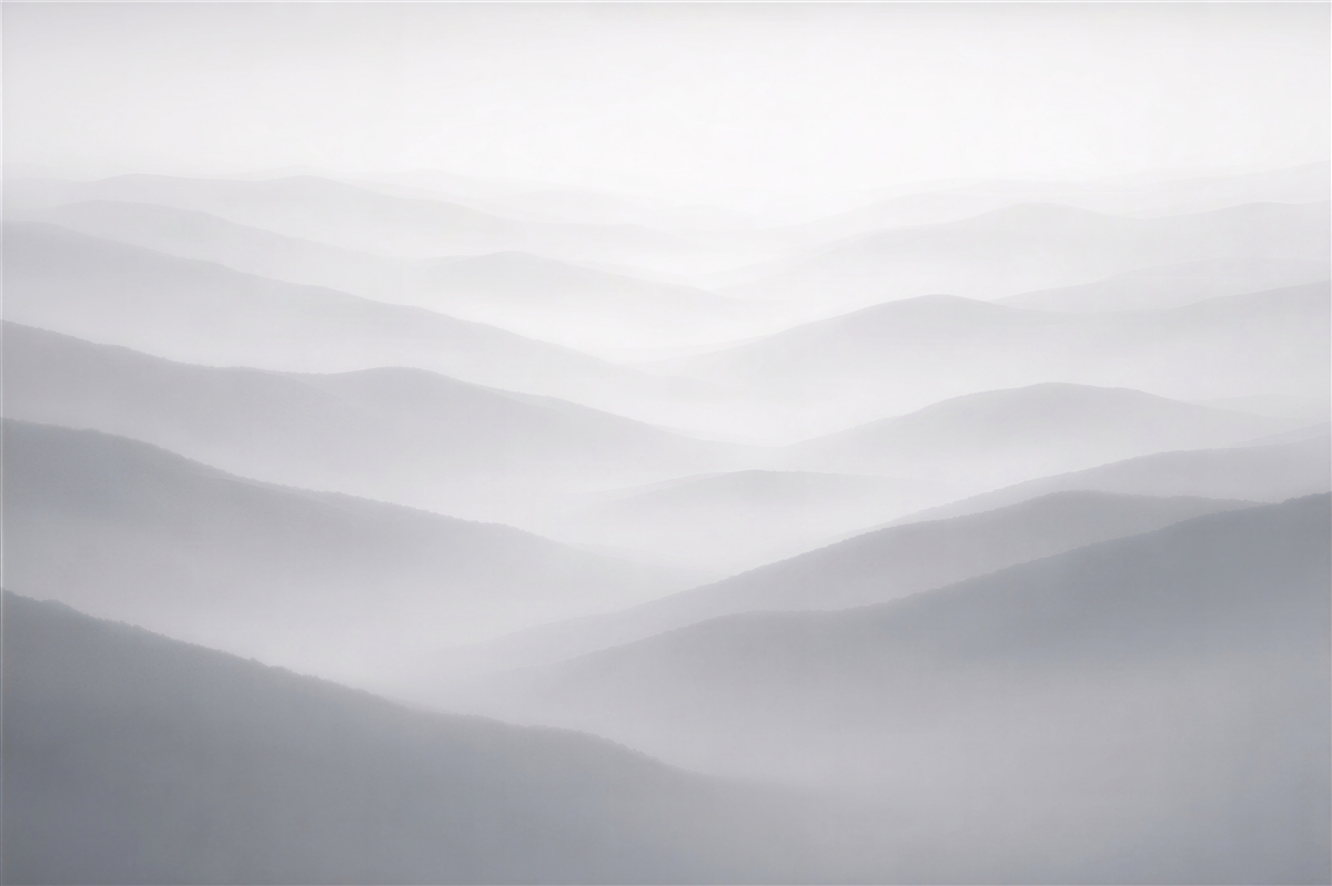 Fototapeten Neblige Landschaft aus Gebirgsschichten